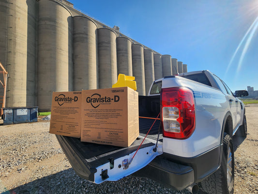 White FSS, Inc. truck with Gravista-D boxes in the back, silos in the background