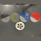 Five metal disc filters with different patterns on a metallic surface
