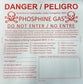 A red and white placard case for Phosphine gas fumigation, detailing safety procedures and equipment requirements.